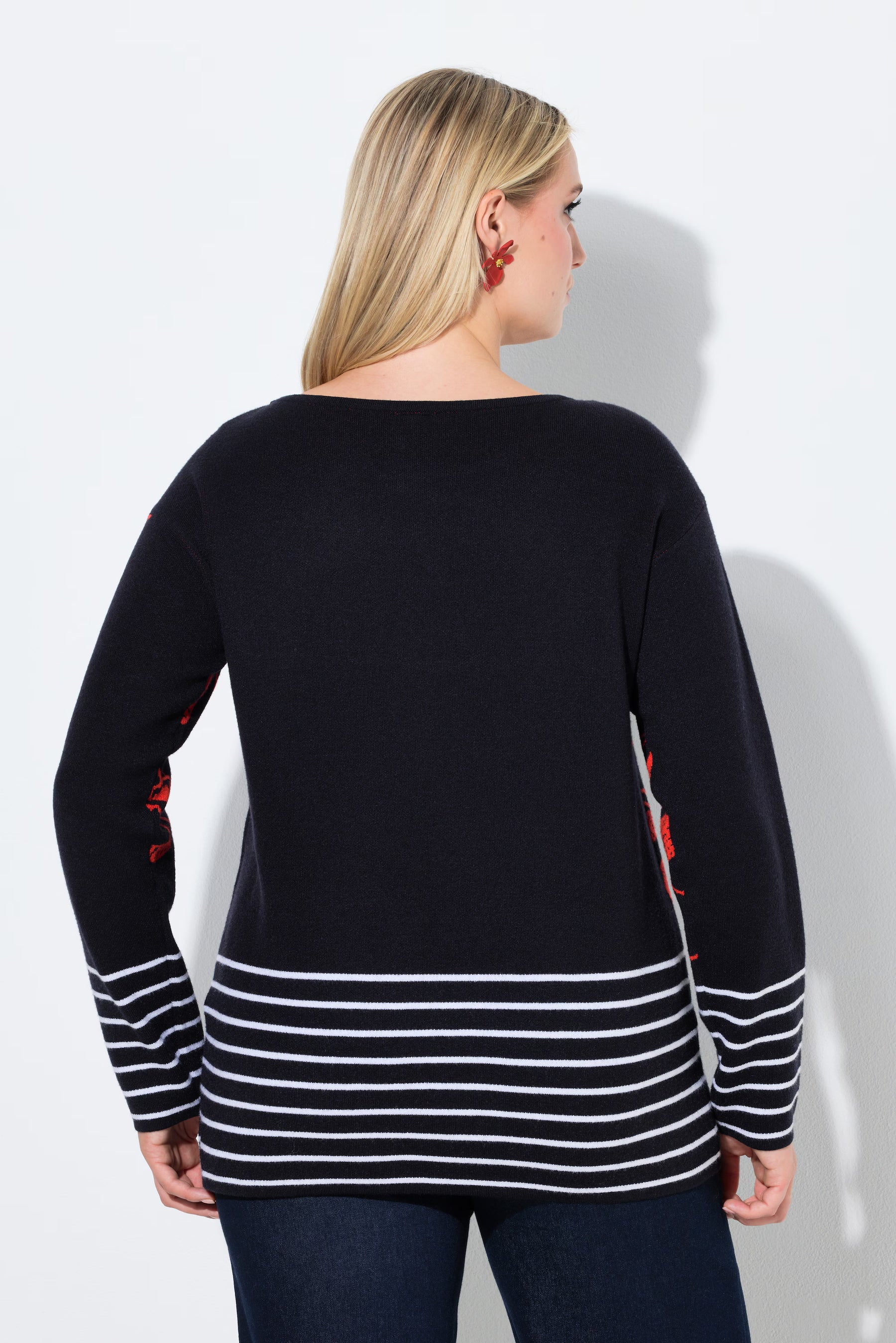 Woman wearing the Ulla Popken Floral Knit Jumper in Black, a black sweater with red accents and white stripes on a plain background