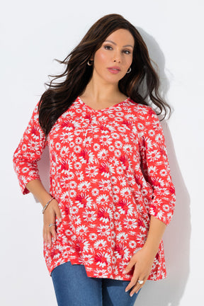Woman wearing the Ulla Popken Flower Top in Red, a red floral top with a pleated V neckline, 3/4 length sleeves and an A-line shape against a white background