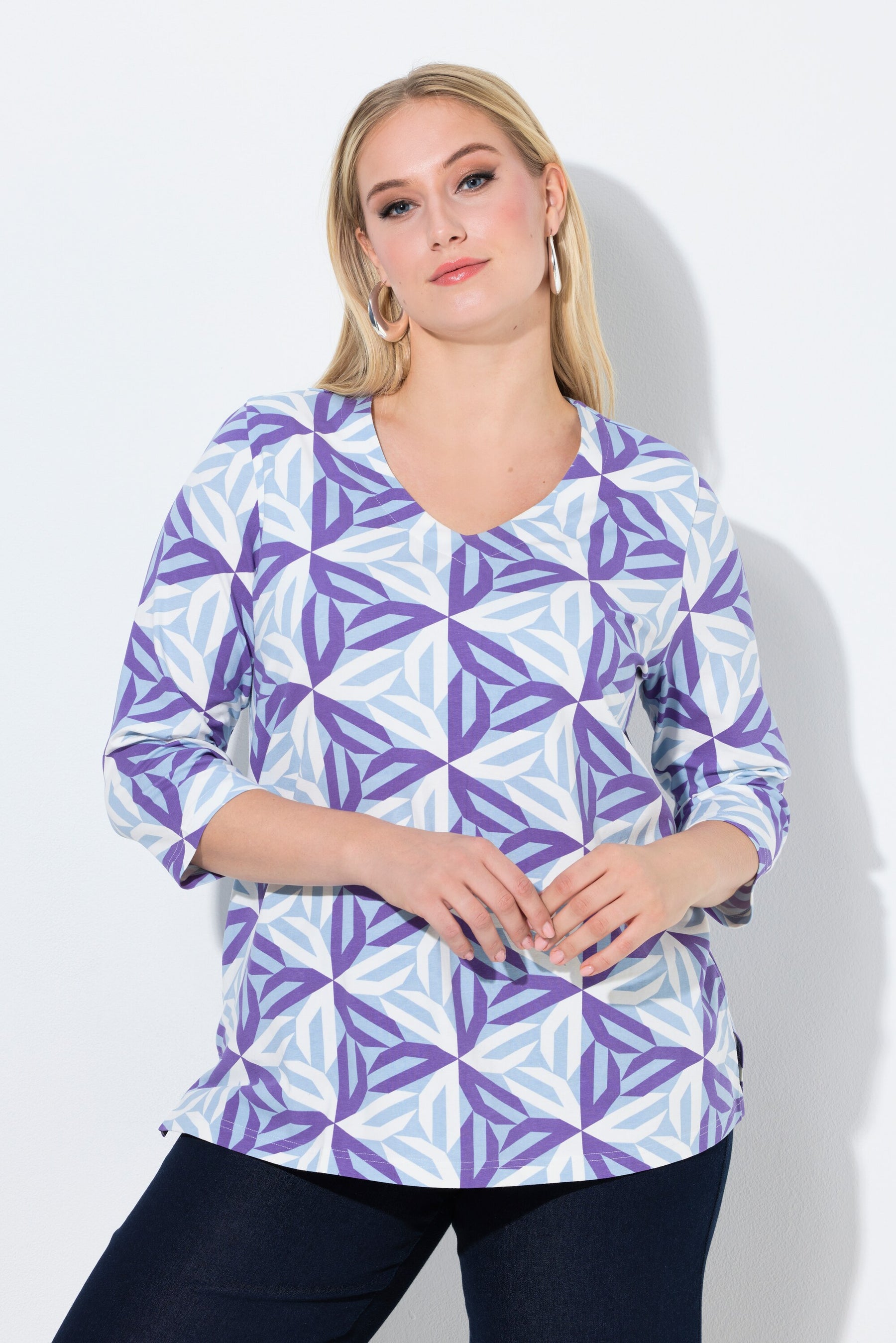 Woman wearing the Ulla Popken Geometric Top in Purple, a purple and blue patterned blouse against a plain background