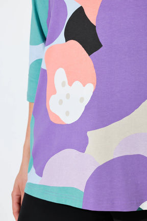 Close-up of the Ulla Popken Multicolor A-Line Top, a colorful abstract pattern on a garment with a white background