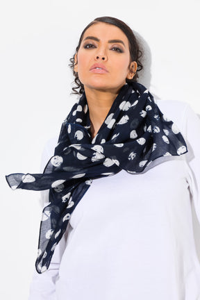 Woman wearing a navy blue scarf with white heart patterns on a white background