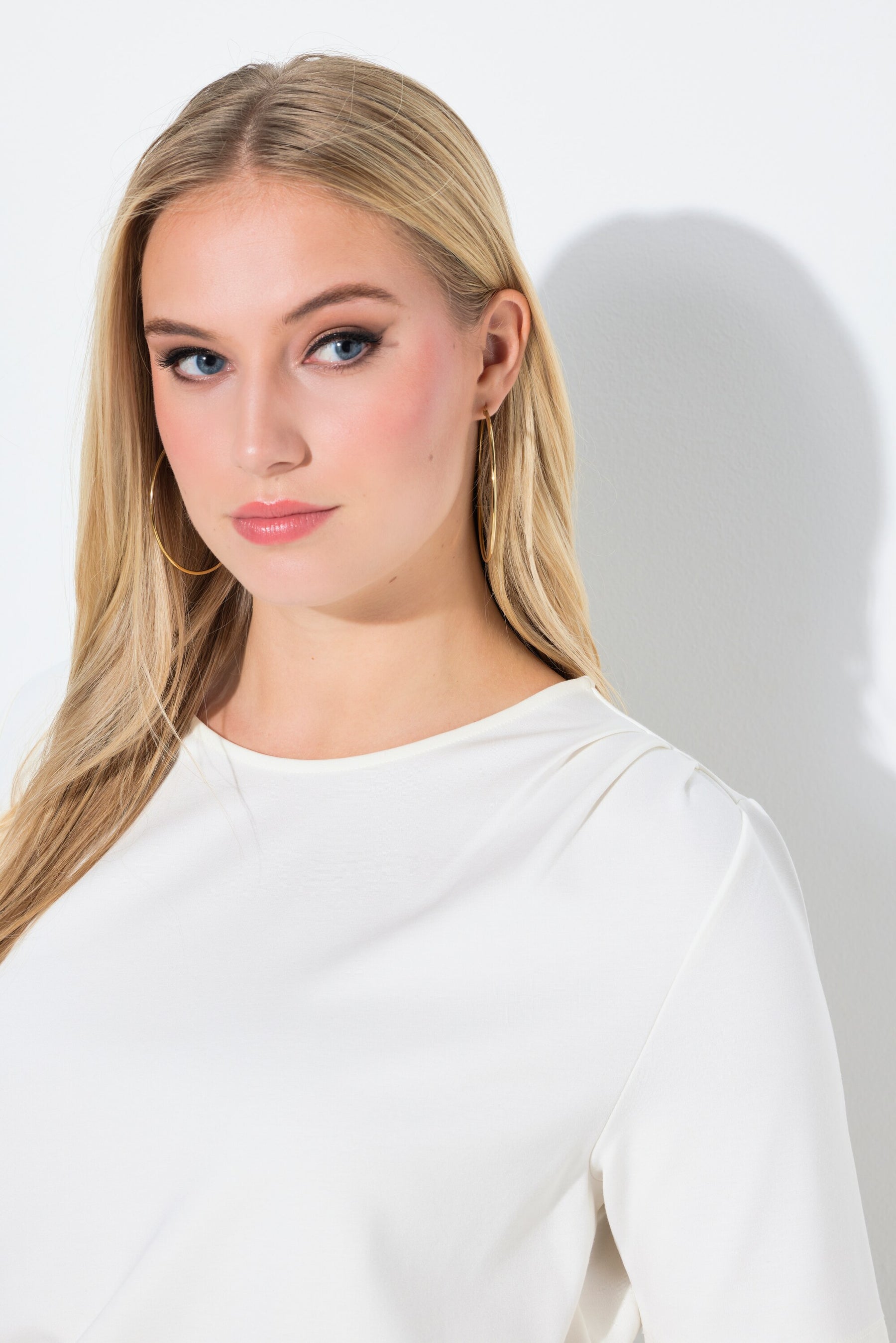 Close up of woman wearing the Ulla Popken Pointed Hem T-Shirt in Off White, a white t-shirt with a round neckline