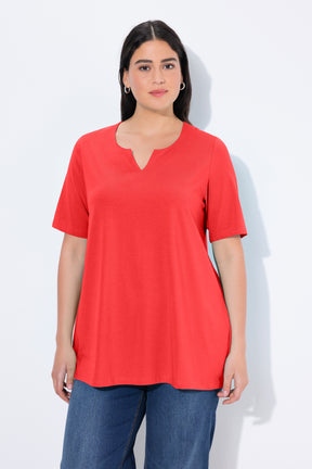 Woman wearing the Ulla Popken Tunic Neck T-Shirt in Red, a red T-shirt with a tunic neckline, short sleeves and an A-line shape with blue jeans against a white background