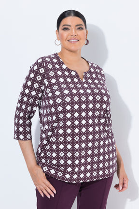 A woman modeling the Ulla Popken Wine Print Blouse, a three-quarter sleeve top with a dark purple and white geometric diamond pattern, paired with matching dark purple pants, against a light gray studio background.