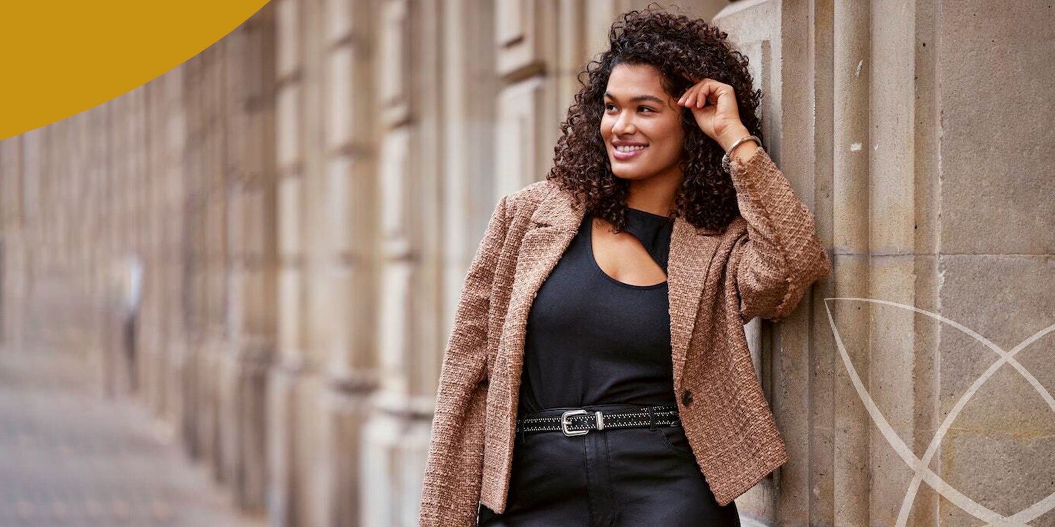 A woman wearing a black top and a brown blazer