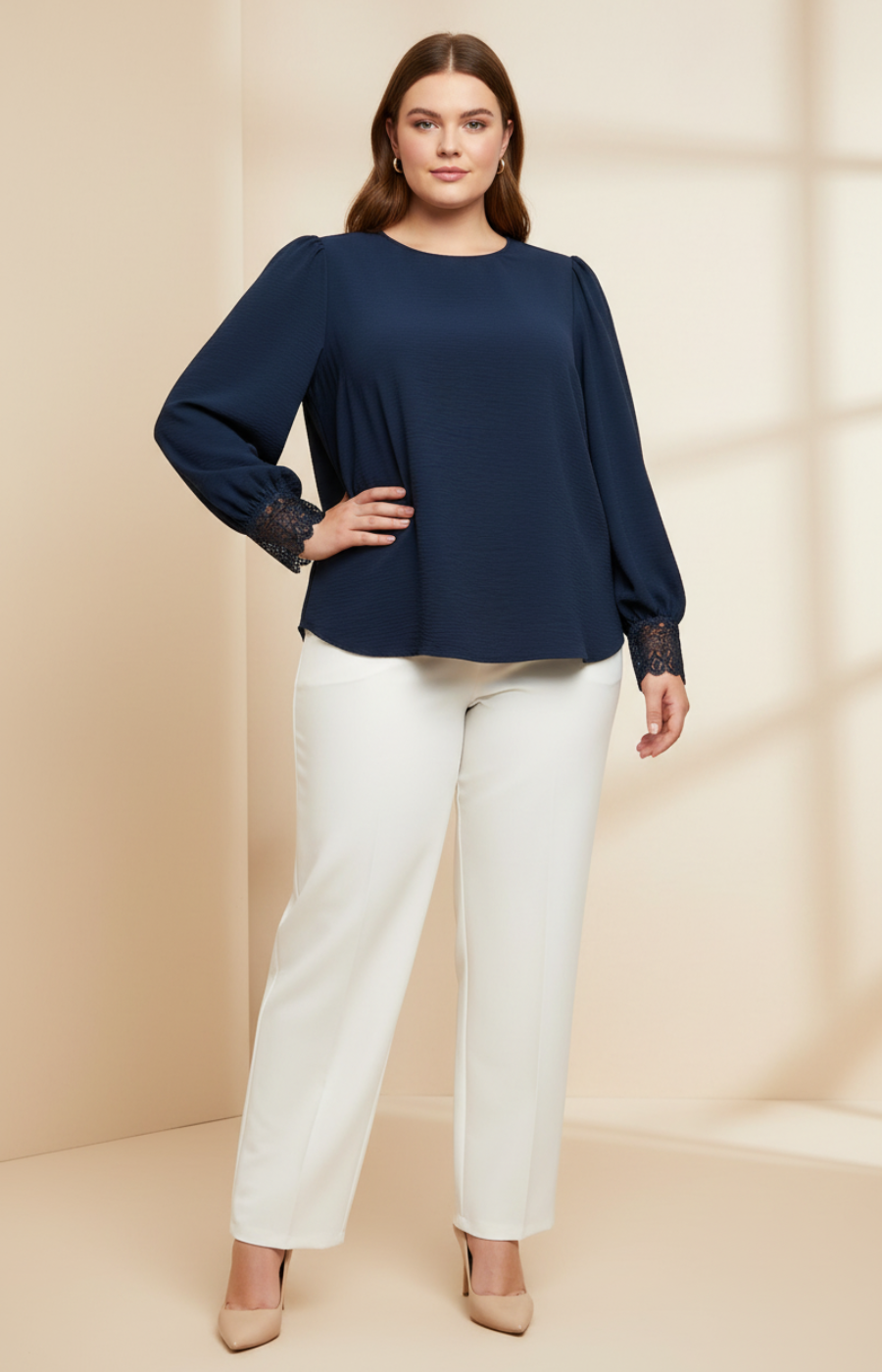 Woman wearing a navy blue top and white pants on a beige background