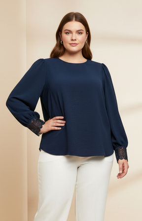 Woman wearing a navy blue blouse with lace cuffs on a beige background