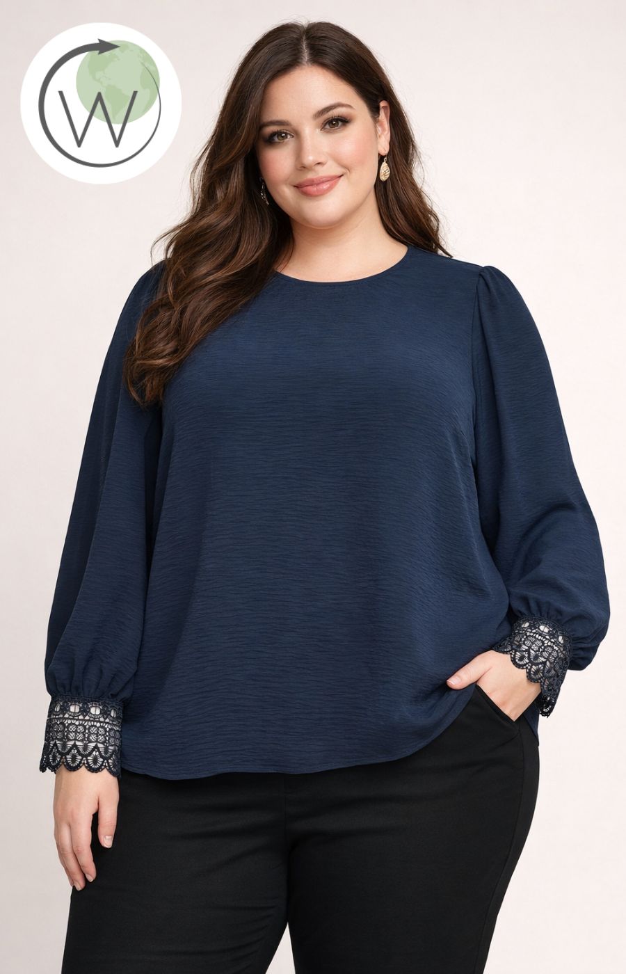 Woman wearing a navy blue top with lace cuffs on a plain background