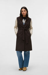 Model is wearing the Vero Moda Curve Fortuneaya Long Waistcoat in Brown, a long line waistcoat with a collar and lapels,tie belt closure, side pockets and a rich, deep chocolate brown shade. This image was created using AI.
