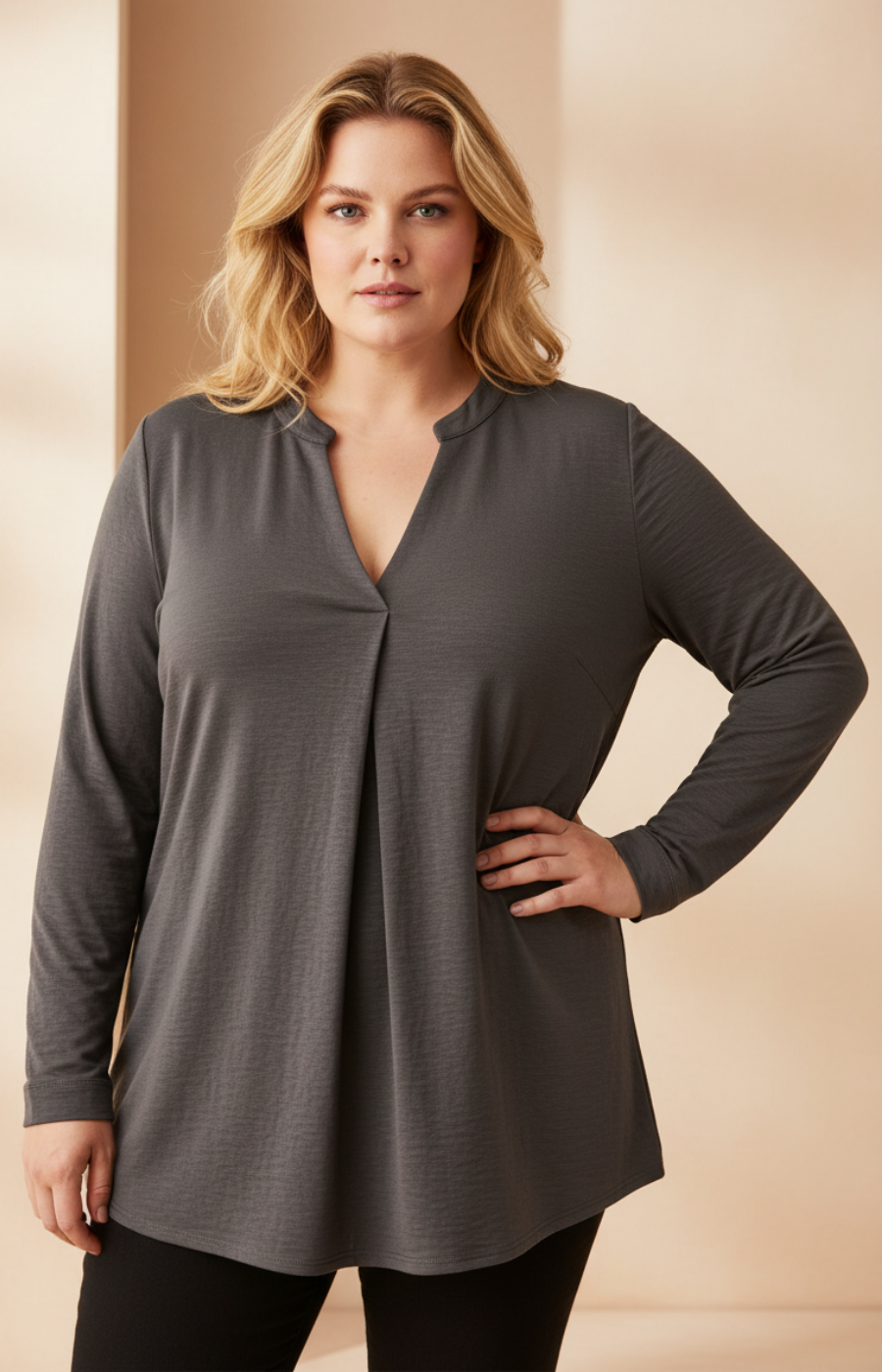 Woman wearing a gray long-sleeve top against a beige background