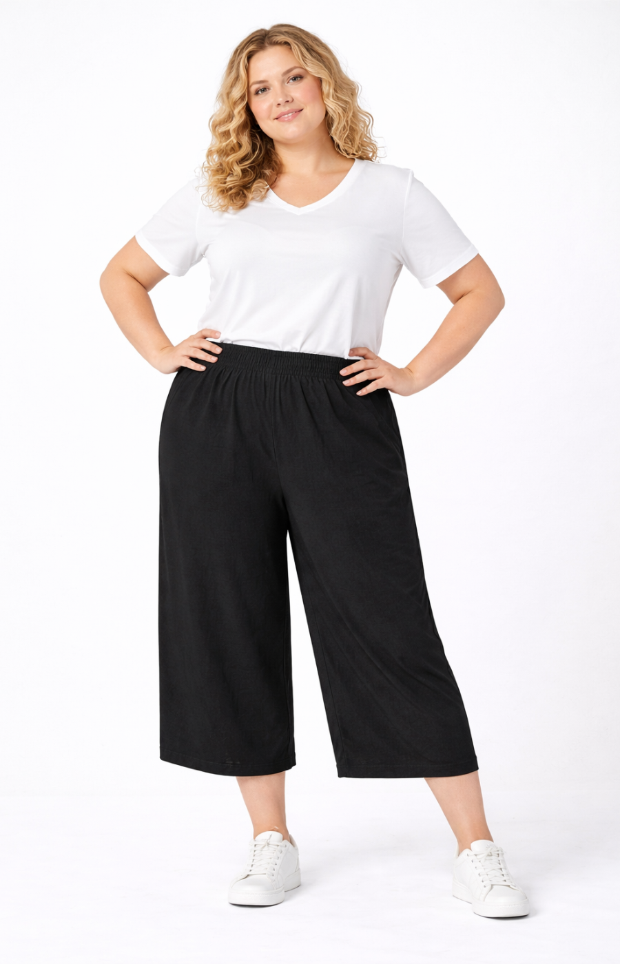 Woman wearing a white t-shirt and black wide-leg pants on a white background