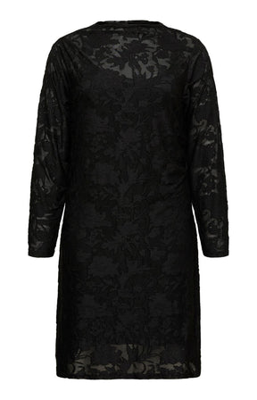 Model wearing the Vero Moda Curve Layla Dress in Black, a knee length black lace dress with a boat neckline and long sleeves. This image was created using AI