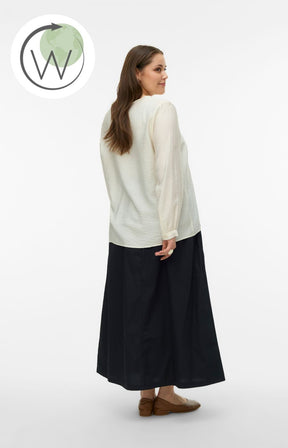 Woman wearing a white blouse with a V neckline and long sleeves, and black skirt on a white background