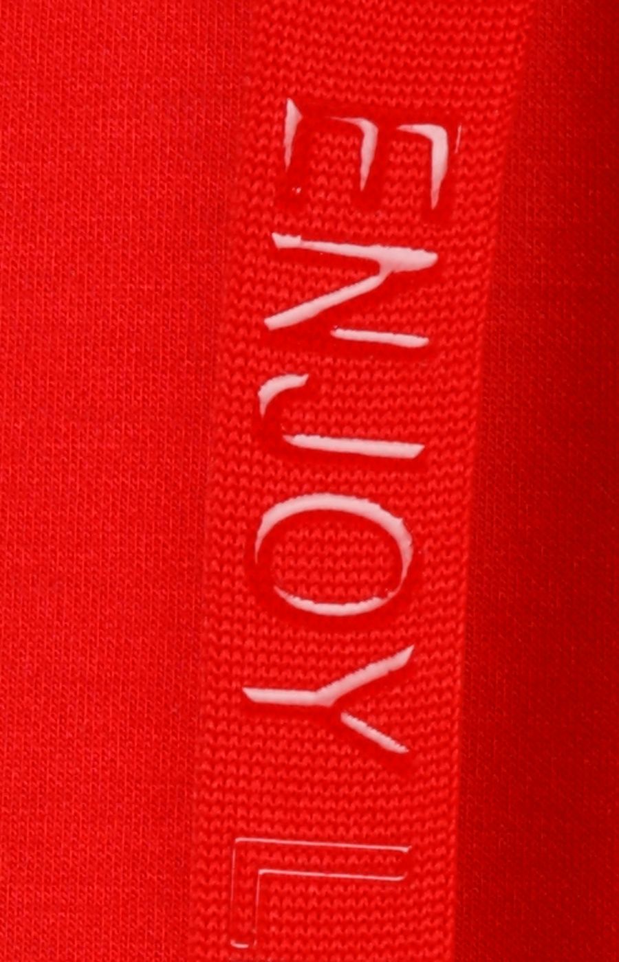 Close-up of a red fabric of the drawstring with 'ENJOY' text embossed on it