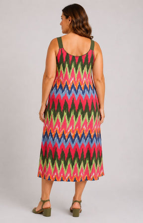Woman wearing the Via Appia Due Zig-Zag Dress, a colorful zigzag patterned dress on a plain background