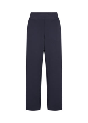 Person wearing the Wasabi Kufa Trousers in Navy, a navy wide-leg  trousers and a striped shirt on a white background 