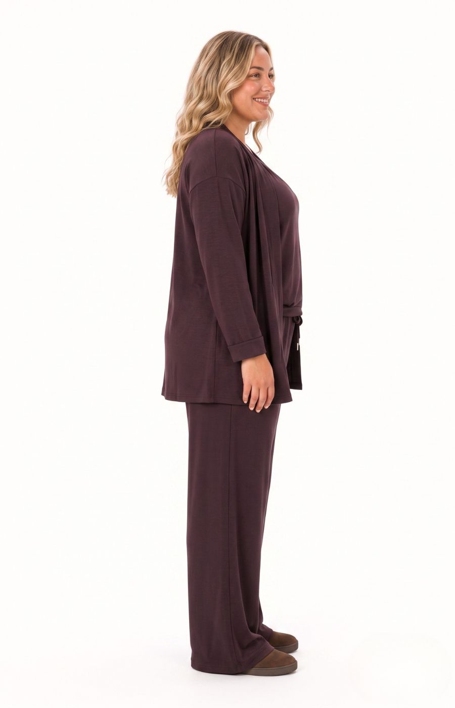 A woman the Wasabi Sabina Pocket Cardigan in Brown, shown in profile against a white background. This image was created using AI