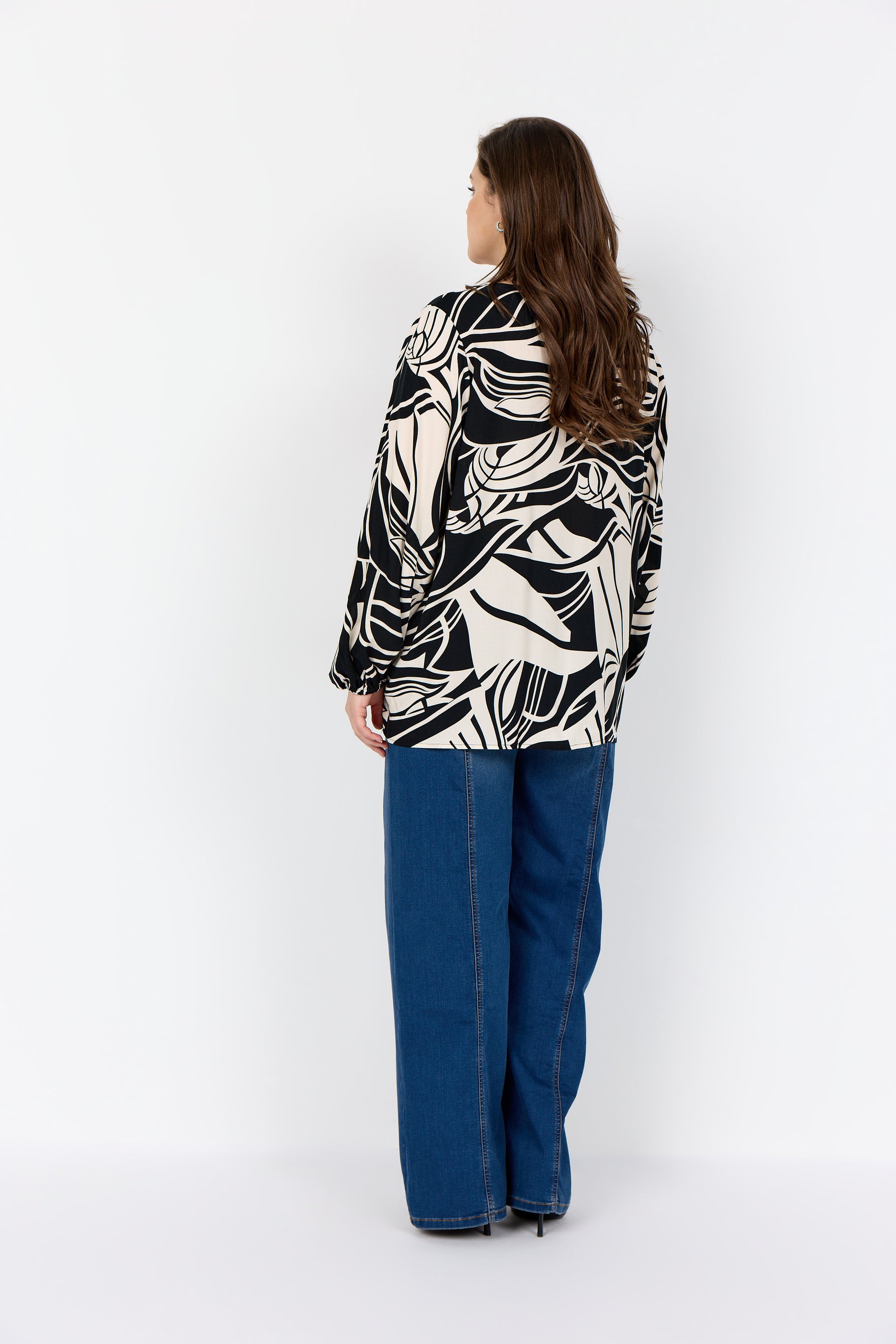 Women wearing the Wasabi Samena Blouse in Black, a patterned blouse with long sleeves 