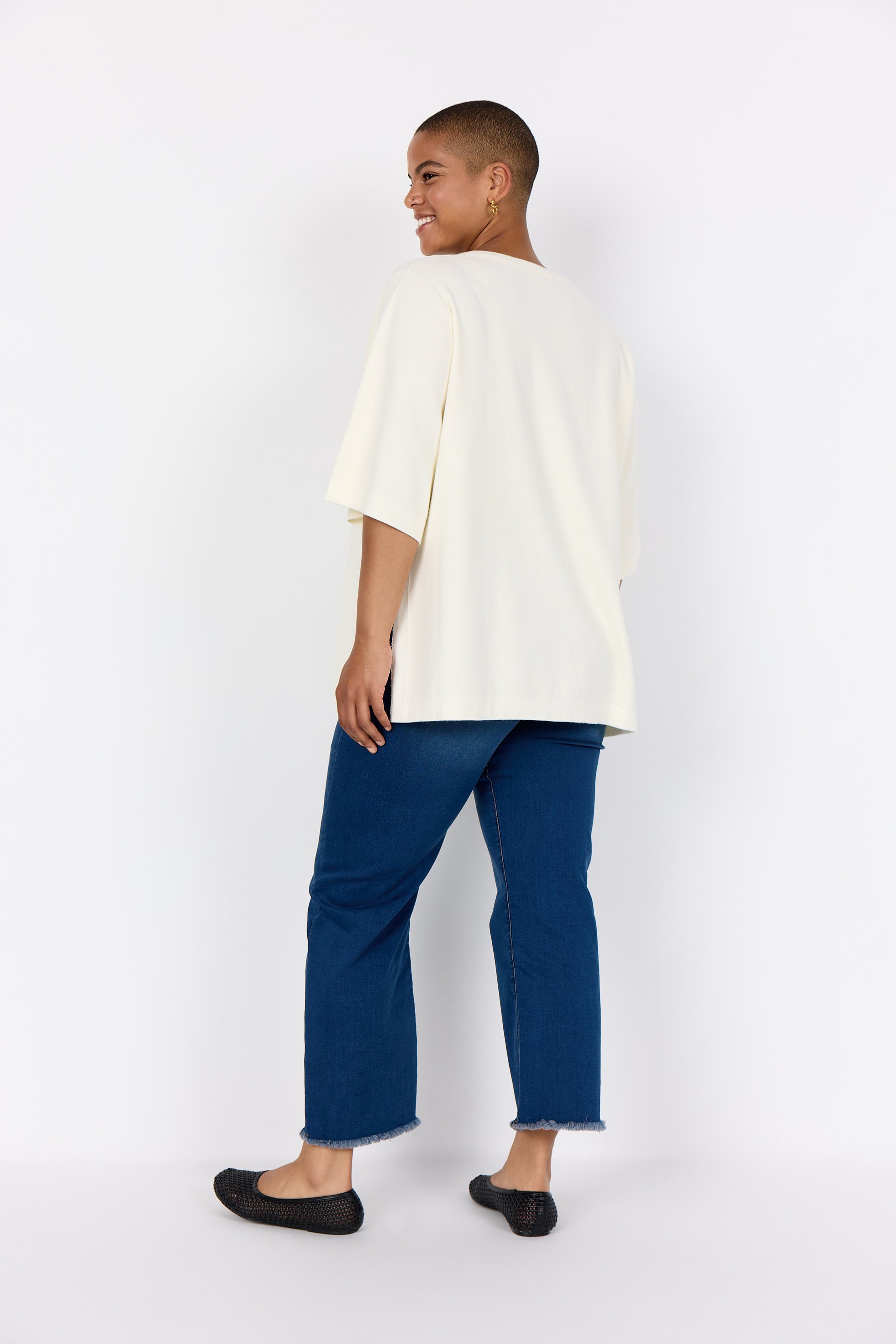 Women wearing Wasabi Sikka Jumper in Cream and blue pants on a white background