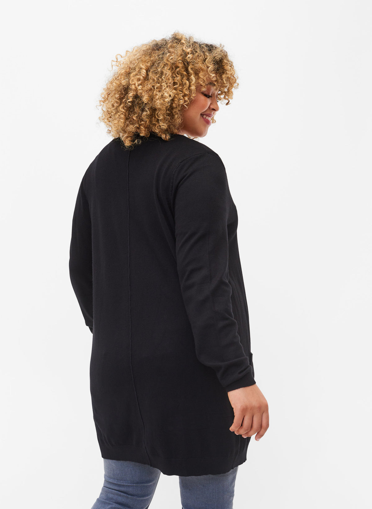 Person wearing a black long line cardigan with long sleeves on a white background