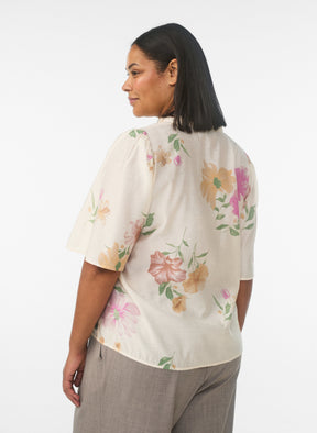 Woman wearing a floral blouse with a white background