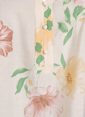 Close-up of a floral patterned fabric with pink and yellow flowers on a beige background.