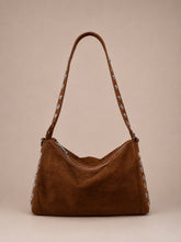 A brown suede shoulder bag with silver-tone metal studs and a matching adjustable strap, shown against a solid beige background.