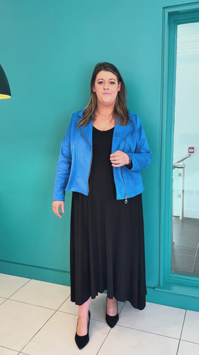 A video of a plus size woman wearing a black maxi dress and a suede biker style jacket in blue.