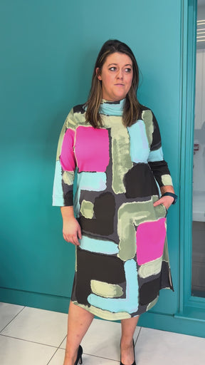 A video of a plus size woman wearing a multi color midi dress