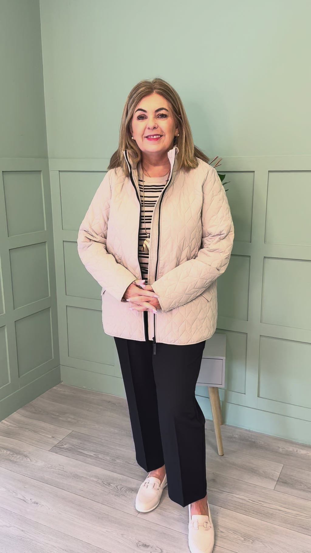 A plus size woman wearing a Kaffe Curve Leina Jacket in Beige with navy trousers and beige loafers.