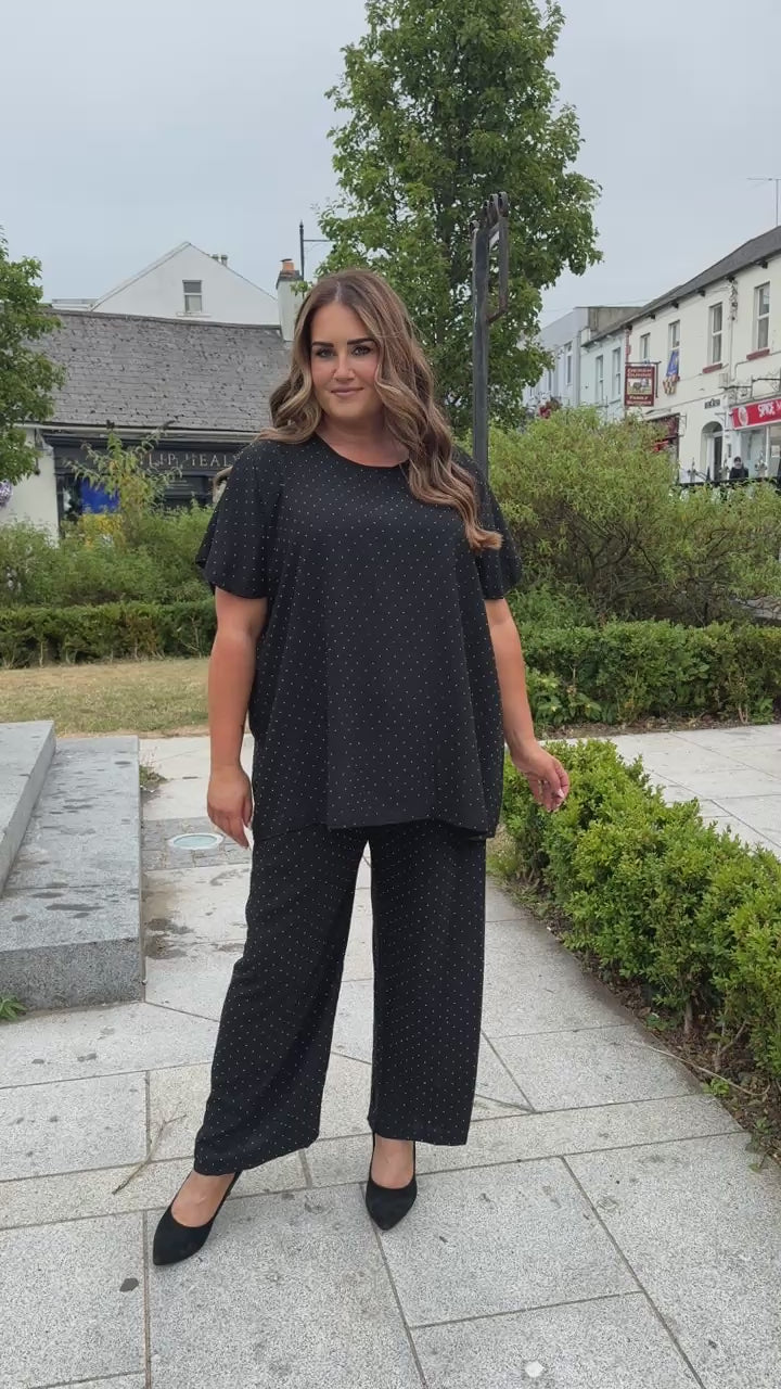 Ali Rhinestone Co-ord in Black, a round neck top with short sleeves and a relaxed fit, with a wide leg trouser, both adored with rhinestones all over 