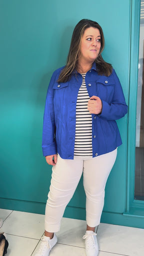 A video of a plus size woman wearing a blue denim style jacket over a striped t-shirt with and white cropped trousers.